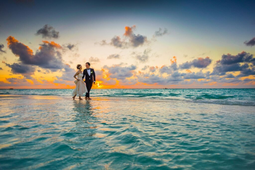 portrait photo - A wedding couple enjoying a romantic beach wedding during a vibrant sunset.